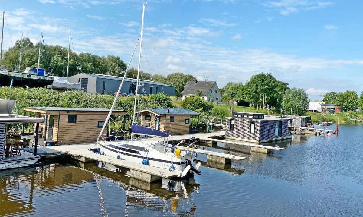 Rustersiel House | Houseboat HT 5 with a fireplace in the lounge, a bedroom, a kitchen, a shower room with a WC and washbasin, and a terrace