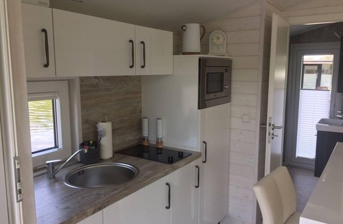 Rustersiel House | Houseboat HT 5 with a fireplace in the lounge, a bedroom, a kitchen, a shower room with a WC and washbasin, and a terrace