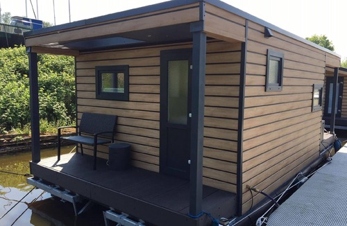 Rustersiel House | Houseboat HT 5 with a fireplace in the lounge, a bedroom, a kitchen, a shower room with a WC and washbasin, and a terrace